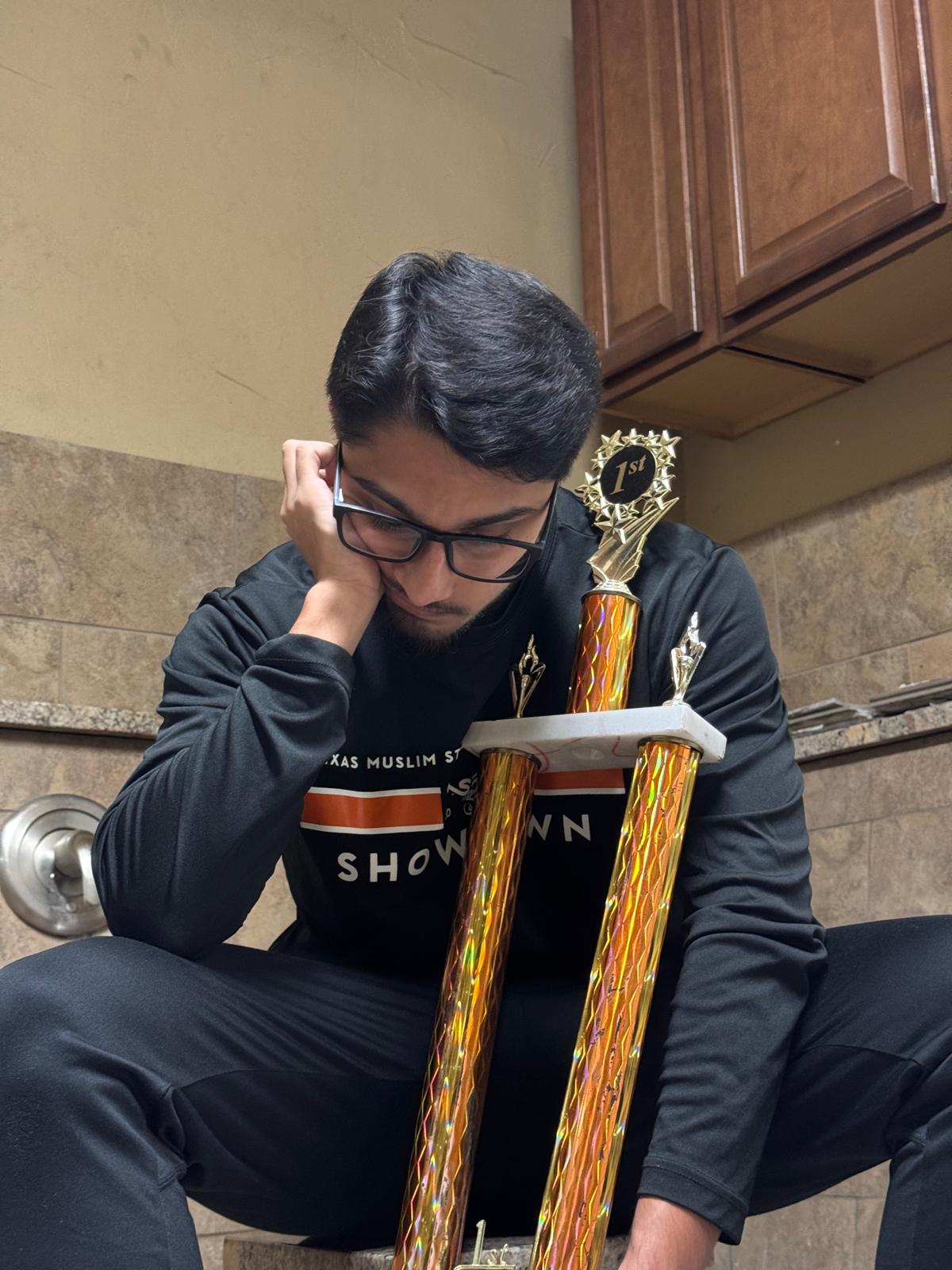 Portrait of Aashir Ahmed holding a first-place trophy